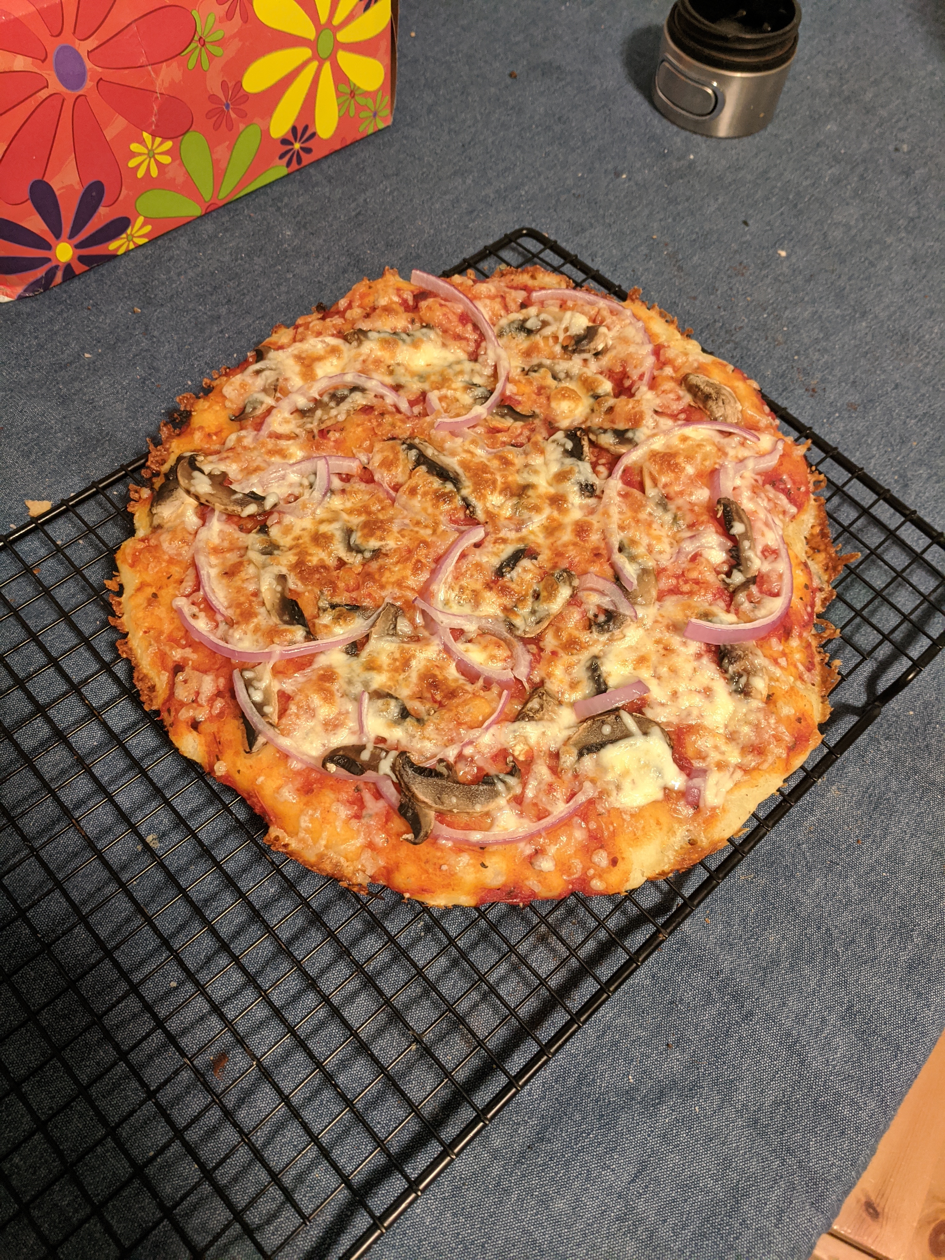Mostly round, crispy cheesy edges, topped with red onion and mushroom.
